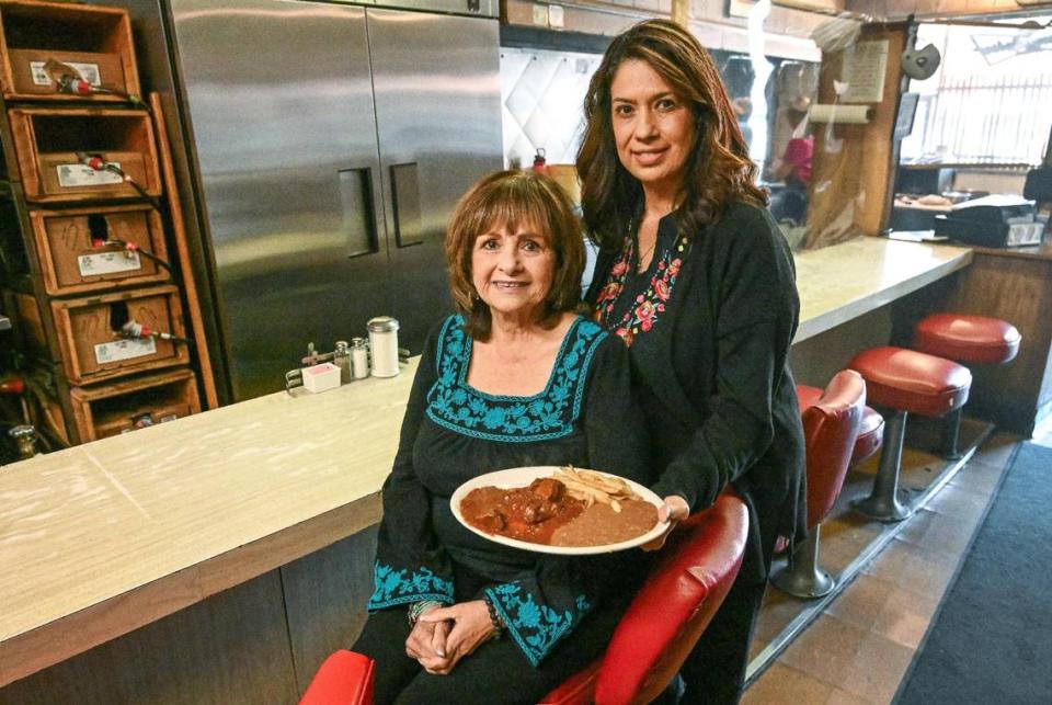 Margaret Sifuentes and her daughter Gina Daniels are photographed with Sifuentes’ secret chili Colorado dish at their restaurant Cuca’s in Fresno’s Chinatown, which is celebrating 50 years, on Thursday, Dec. 14, 2023.