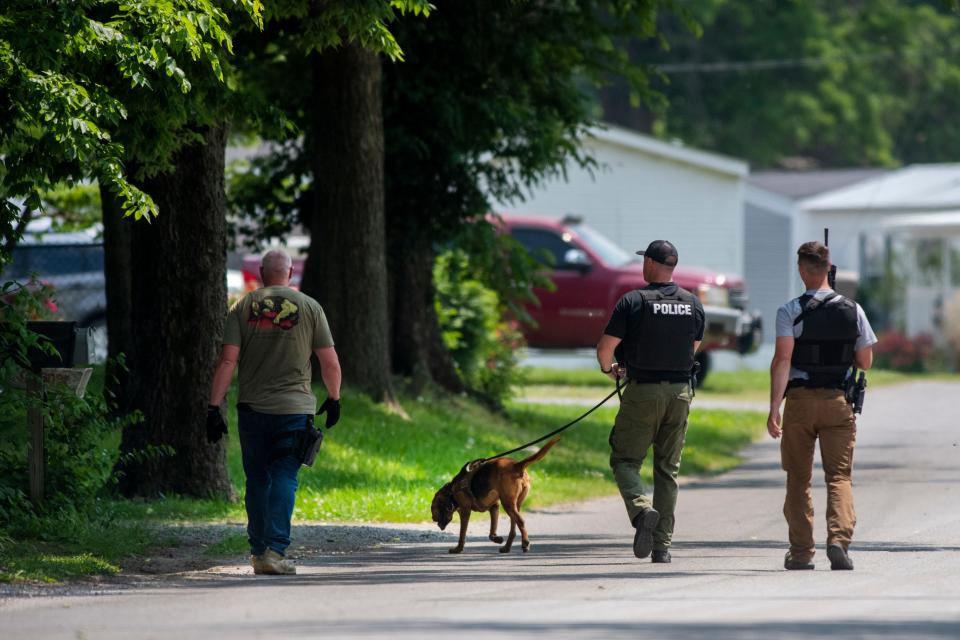 Law enforcement officers walk a mantrailing dog down Sunset Lane as they search for escaped Ohio inmate 50-year-old Bradley Gillespie after an early-morning car chase reportedly led to the capture of the escapee's partner Henderson, Ky., Wednesday, May 24, 2023.