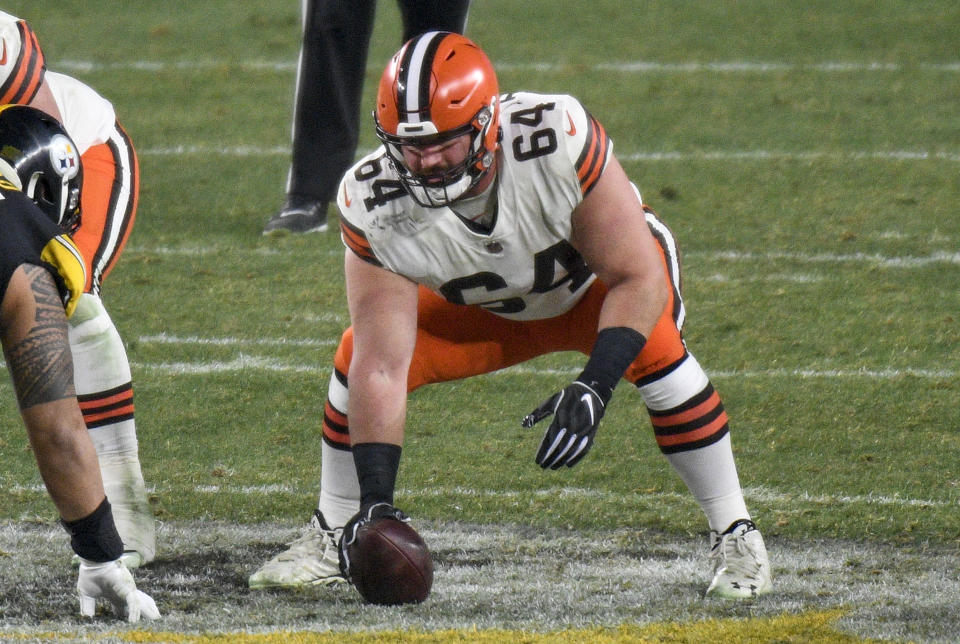 FILE - In this Jan. 10, 2021, file photo, Cleveland Browns center JC Tretter (64) snaps the ball during the first half of an NFL wild-card playoff football game against the Pittsburgh Steelers in Pittsburgh. Following the advice of Browns center and NFL Players Association President Tretter, Cleveland's players joined a list of teams who say they will skip voluntary in-person workouts this offseason. (AP Photo/Don Wright, File)