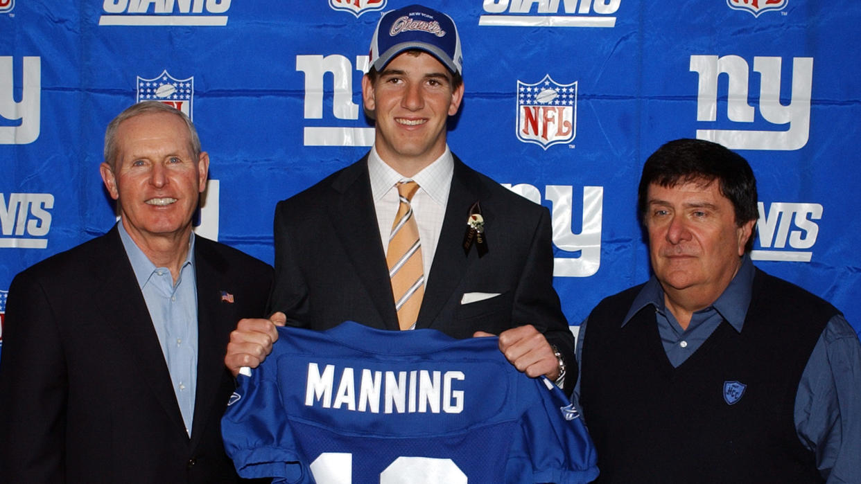 Mandatory Credit: Photo by Bill Kostroun/AP/Shutterstock (6416863d)MANNING ACCORSI COUGHLIN New York Giants draft pick Eli Manning holds up his new Giants jersey as he poses with coach Tom Coughlin, left, and general manager Ernie Accorsi, in East Rutherford, N.