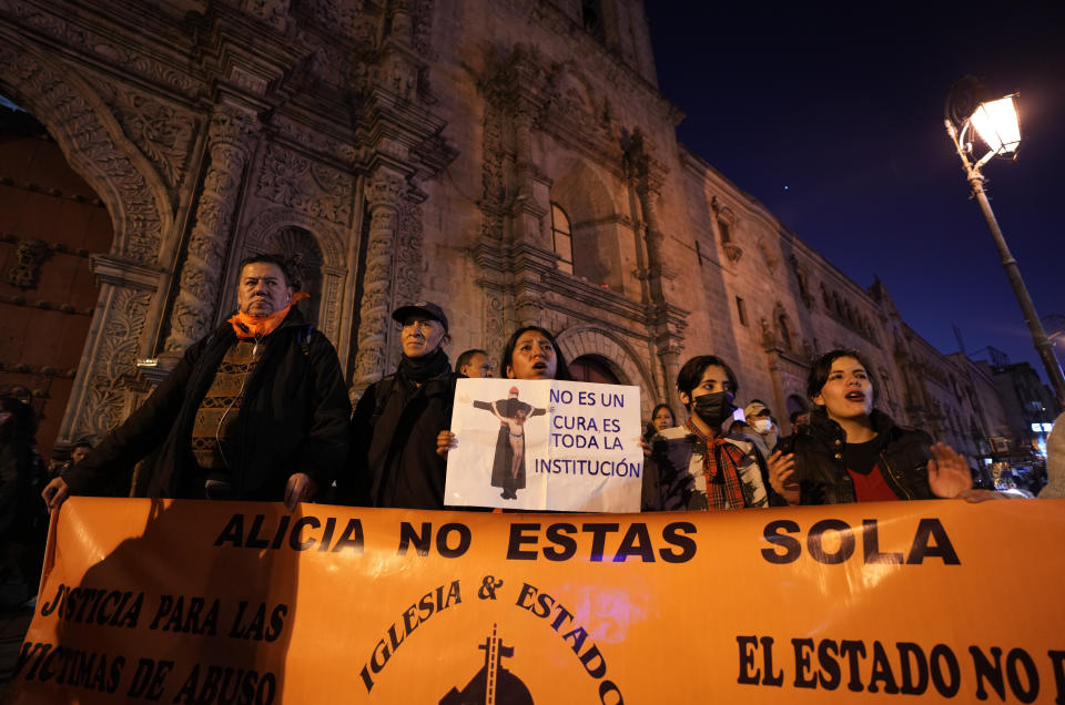 Personas se reúnen frente a la Basílica de San Francisco para exigir justicia para las víctimas de sacerdotes pedófilos, en La Paz, Bolivia, el viernes 2 de junio de 2023. (AP Foto/Juan Karita).