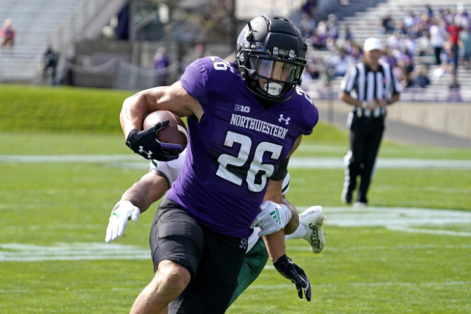 Northwestern running back Evan Hull (26) scores a touchdown past Ohio cornerback John Gregory during the first half of an NCAA college football game in Evanston, Ill., Saturday, Sept. 25, 2021. (AP Photo/Nam Y. Huh)