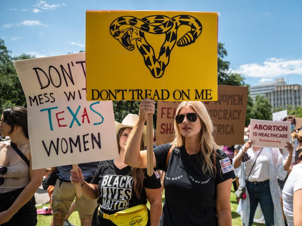 Protesters hold up signs at a protest against Texas' new abortion law outside the state capitol on May 29, 2021 in Austin, Texas.