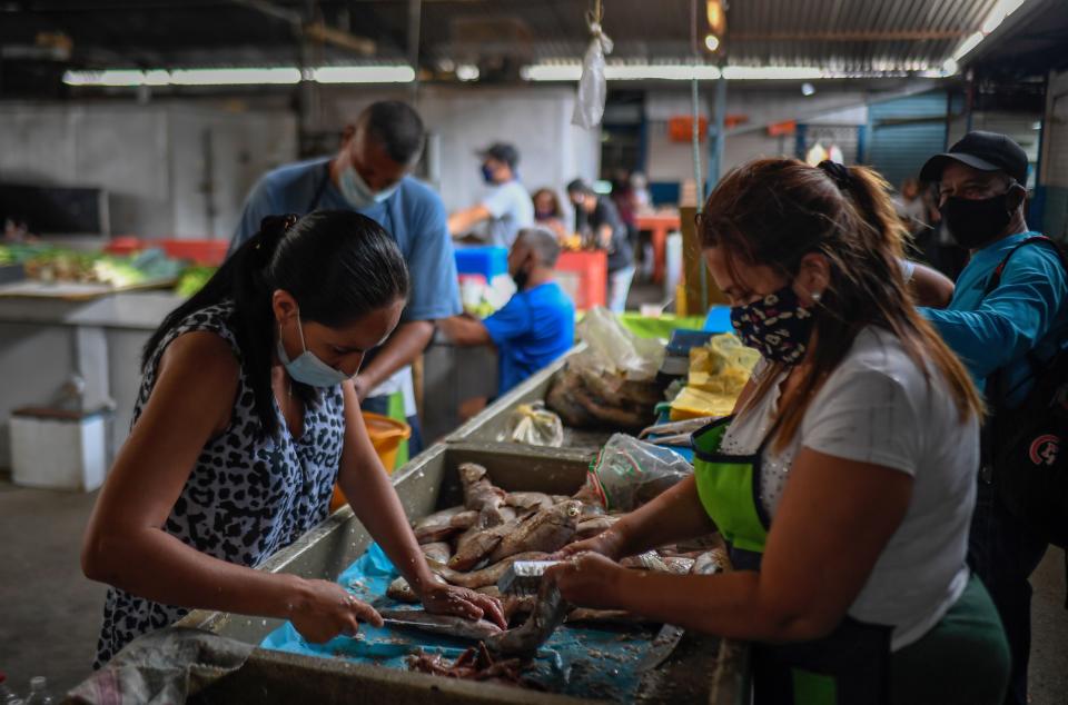 Vendors clean fish at the municipal market of Chacao in Caracas amid the COVID-19 novel coronavirus pandemic, on September 3, 2020 as inflation increases in Venezuela which is in the midst of the worst economic crisis in its history after seven years of recession. - Venezuela is sitting on the world's largest proven oil reserves but under Nicolas Maduro's watch, the country has descended into crisis. Poverty has soared, inflation is the highest in the world, the currency has become practically worthless, and oil production is down to its lowest level in 77 years, which experts blame on mismanagement and corruption. (Photo by Federico PARRA / AFP) (Photo by FEDERICO PARRA/AFP via Getty Images)