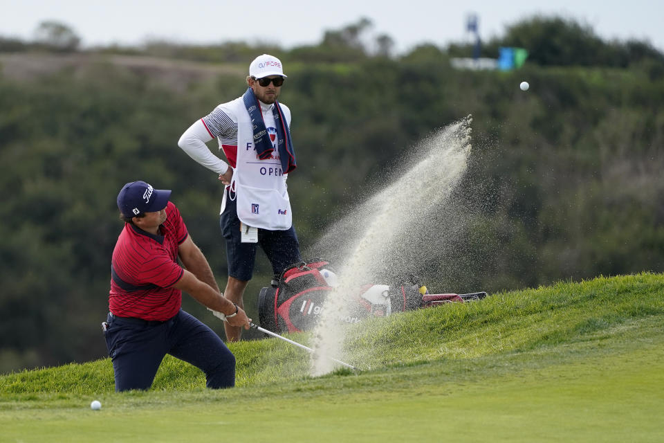 Patrick Reed hits from a bunker toward the 14th hole on the South Course during the final round of the Farmers Insurance Open golf tournament at Torrey Pines, Sunday, Jan. 31, 2021, in San Diego. (AP Photo/Gregory Bull)