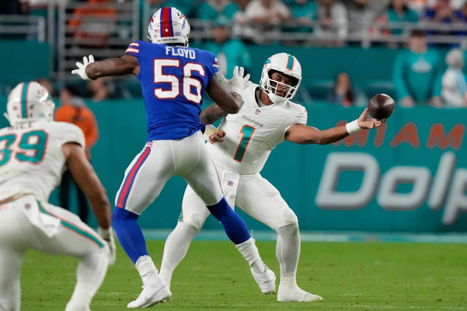 Miami Dolphins quarterback Tua Tagovailoa (1) throws a pass around Buffalo Bills defensive end Leonard Floyd (56) during the first half of an NFL football game, Sunday, Jan. 7, 2024, in Miami Gardens, Fla. (AP Photo/Lynne Sladky)