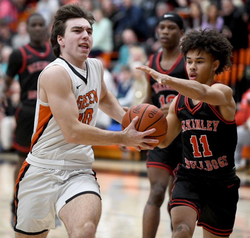 Green's Brady Rollyson charges past McKinley's Davey Thompson to put in two points in the first quarter of McKinley at Green boys basketball. Friday, February 09, 2024.