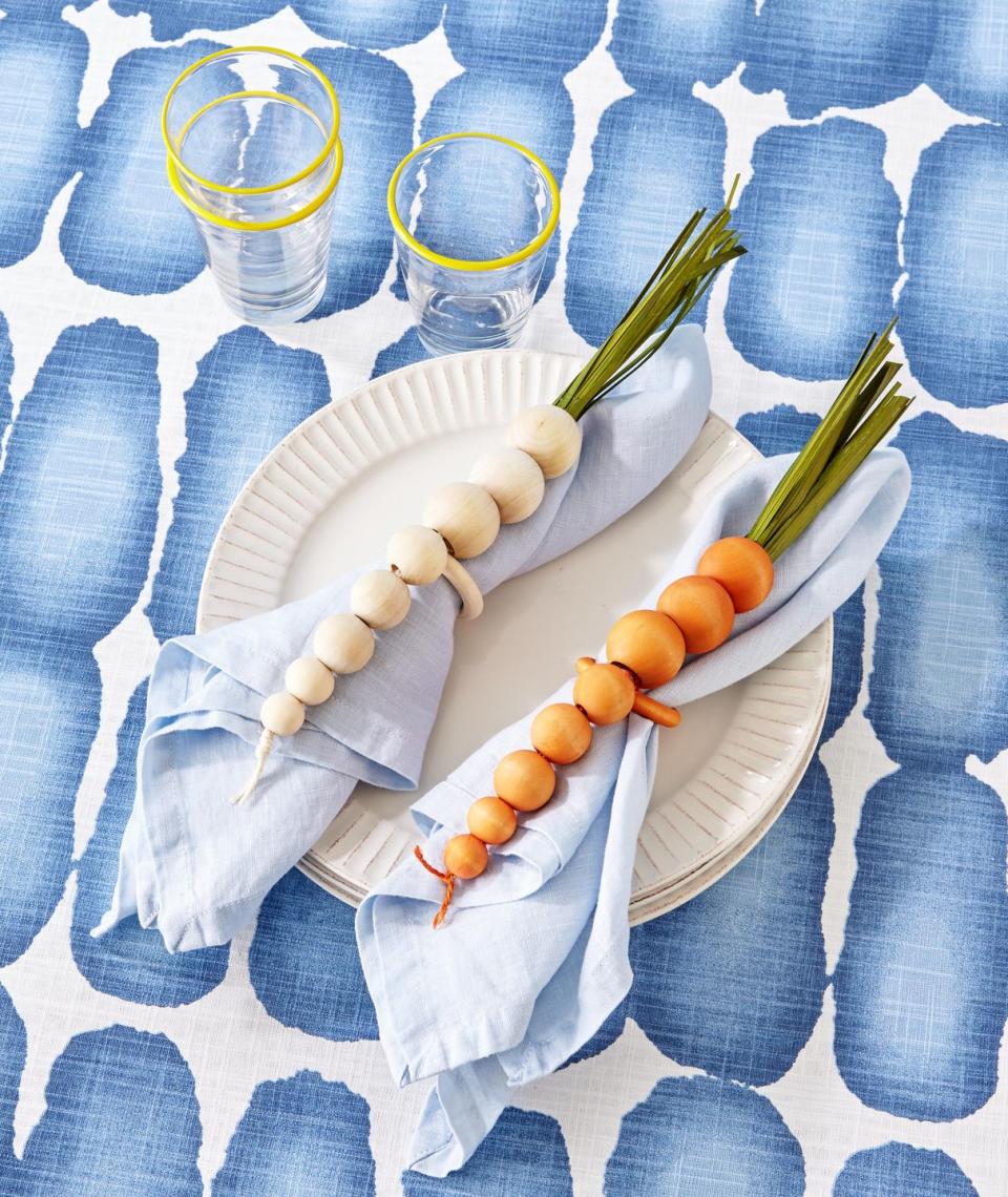 <p>Made from mini wooden craft beads, these napkin rings mimic bunnies favorite foods, root veggies!</p><p><strong>To make:</strong> Dye wooden craft beads orange or white. Arrange eight beads small to large in a row, and thread a piece of twine in a corresponding color through beads; knot on both ends. Wrap a wooden craft ring with twine, and tie between the beads for the napkin holder. For the stems, attach lengths of preserved grass or green crepe paper to the top with hot-glue.</p><p><a class="link " href="https://www.amazon.com/Natural-Unfinished-Suitable-Holiday-Jewelry/dp/B08KD9R28B/ref=sr_1_5?tag=syn-yahoo-20&ascsubtag=%5Bartid%7C10050.g.1111%5Bsrc%7Cyahoo-us" rel="nofollow noopener" target="_blank" data-ylk="slk:SHOP WOODEN BEADS;elm:context_link;itc:0;sec:content-canvas">SHOP WOODEN BEADS</a></p>