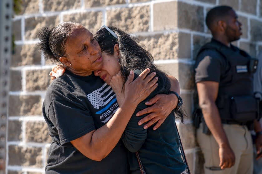 Jeanne LeGall hugs Claudia Carballada as they pay their respects at a memorial in Buffalo