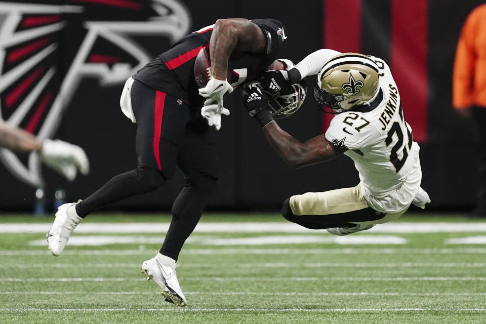 Atlanta Falcons running back Mike Davis (28) is hit by New Orleans Saints safety Malcolm Jenkins (27) causing Davis to fumble during the first half of an NFL football game, Sunday, Jan. 9, 2022, in Atlanta. (AP Photo/John Bazemore)