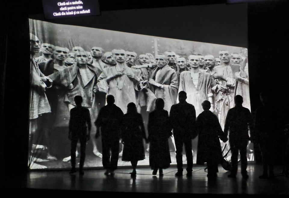 Actors of the Romania's Jewish State Theatre rehearse the musical drama "The Lights of the Ghetto" a mix of music and stories by Holocaust survivors in Bucharest, Romania, Saturday, Jan. 26, 2019, a day before the premiere on International Holocaust Remembrance Day. About 280,000 Romanian Jews and 11,000 Romanian Roma, or Gypsies, were deported and killed during WWII when Romania was ruled by a pro-nazi regime. Text reads "Sing a song for me - Sing with your soul and from your heart". (AP Photo/Vadim Ghirda)