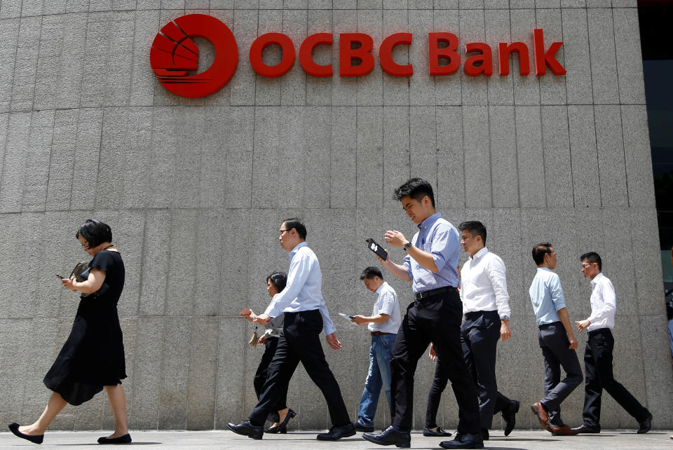 Office workers walk past an OCBC Bank building in Singapore, October 8 2019. REUTERS/Feline Lim