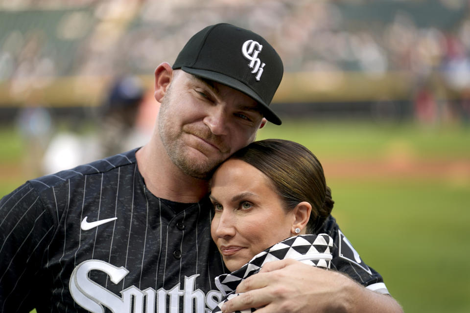 Chicago White Sox's Liam Hendriks, top, hugs his wife Kristi as he is honored before a baseball game against the Los Angeles Angels, Monday, May 29, 2023, in Chicago. Hendriks returns to the active lineup after battling cancer at the start of the season. (AP Photo/Charles Rex Arbogast)