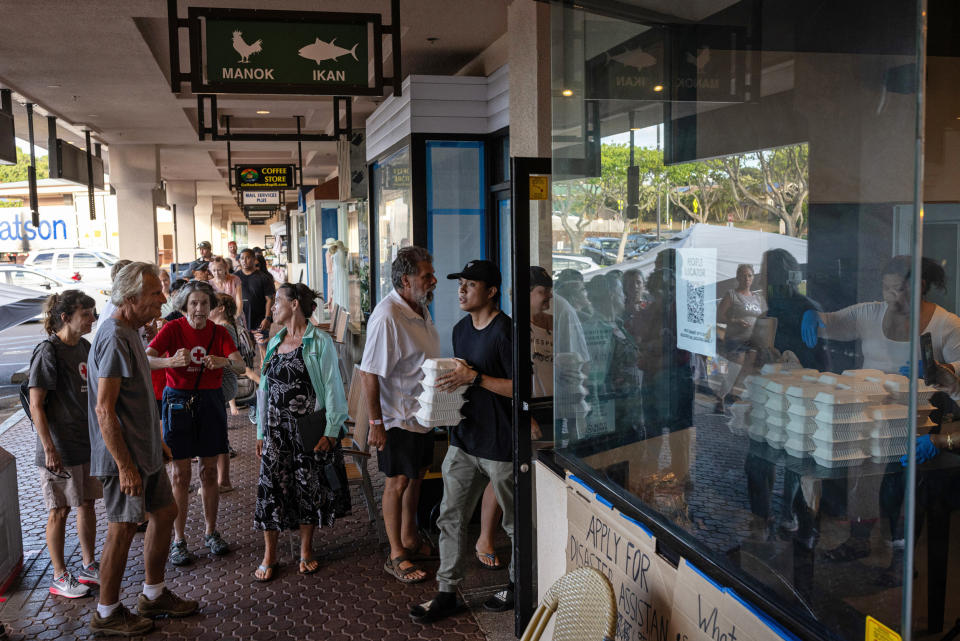 People stand in line to pick up free venison chili for dinner at Joey's Kitchen, a Hawaiian-Filipino fusion restaurant, in Napili on West Maui on Aug. 21, 2023.  (Tamir Kalifa / The Washington Post via Getty Images)