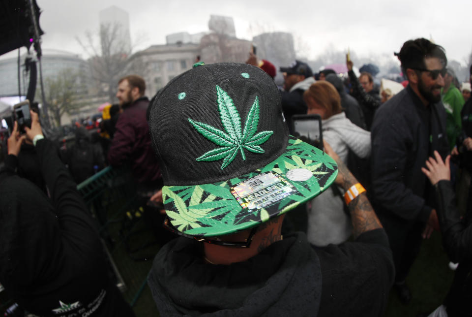 FILE - In this April 20, 2018 file photo, an attendee celebrates at 4:20 p.m. by lighting up marijuana during the Mile High 420 Festival in Denver. New research has found some Colorado teenagers who use marijuana are shifting away from smoking it in favor of edible products. About 78% of the Colorado high school students who reported consuming marijuana in 2017 said smoking was their usual method, down from 87% two years earlier. The number of teens who usually consumed edible marijuana products climbed to about 10% from 2% in the same two-year span while the number of users dabbing increased to about 7.5% from 4%. (AP Photo/David Zalubowski, File)