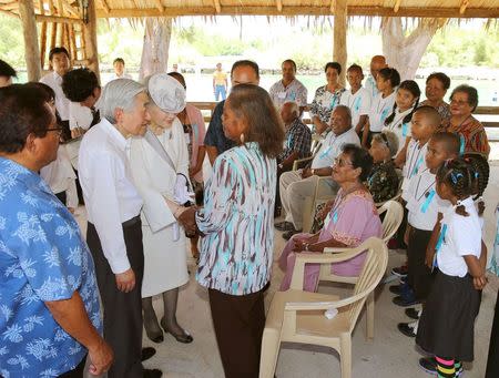 Japan's Emperor Akihito (2nd L) and Empress Michiko (3rd L) talk with local residents as they visit Palau's Peleliu Island, in this photo released by Kyodo April 9, 2015. Mandatory Credit REUTERS/Kyodo