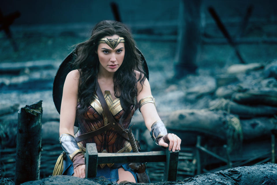 Gal Gadot as Wonder Woman, wearing her iconic warrior outfit with a headband and armored corset, standing on a battlefield