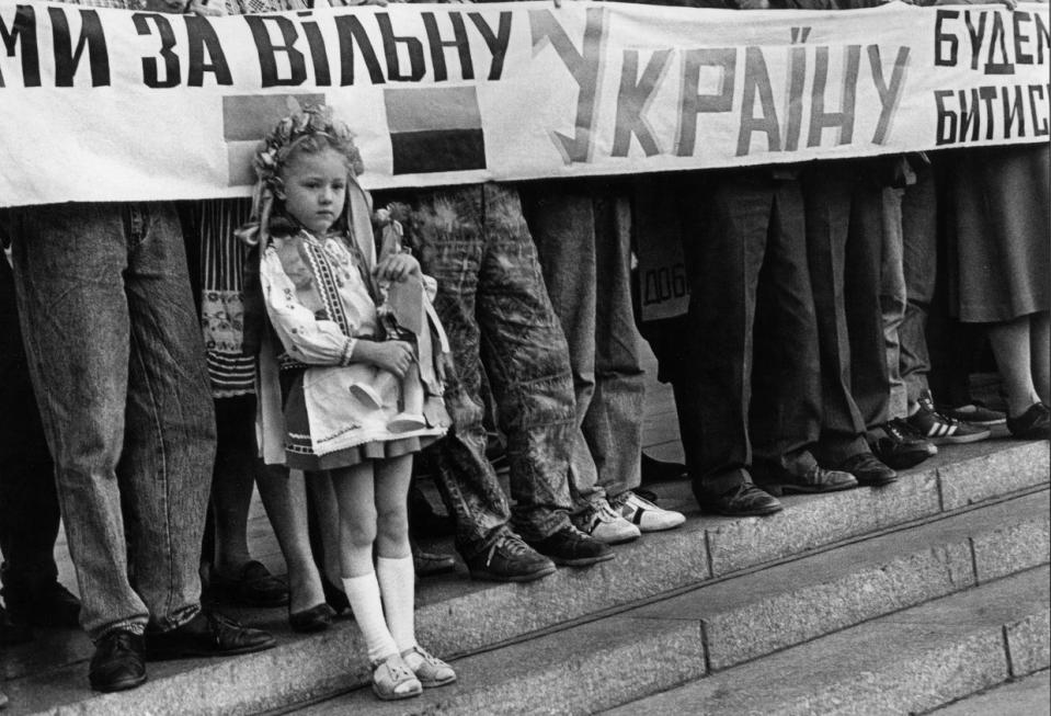 A girl in a traditional Ukrainian outfit, vyshyvanka, stands next to the Ukrainian Popular Assembly participants during their rally near the fenced demolition monument of the October Revolution on Maidan Nezalezhnosti in Kyiv, Ukraine, Sep. 15, 1991. The Ukrainian Popular Assembly (known as Viche) was held in the center of Kyiv in support of the Act of Declaration of Independence of Ukraine from the USSR adopted on Aug. 24, 1991. (Andrii Nesterenko/Global Images Ukraine via Getty Images)