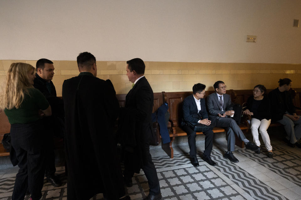 The defendant and his attorneys, next to the representatives of the South Korean Embassy wait in front of the courtroom before the trial of the captain of a river cruise boat starts in Budapest, Hungary, Tuesday, September 26, 2023. The captain of a river cruise boat that collided with another vessel in Hungary's capital in 2019, killing at least 27 mostly South Korean tourists has been found guilty of negligence and sentenced to five years and six months in prison. (AP Photo/Denes Erdos)