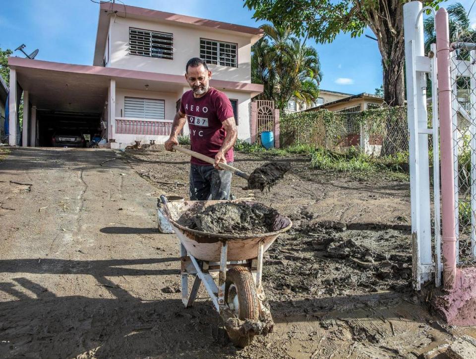 Samuel Santiago removes mud from the front of his house in the San Jose de Toa Baja neighborhood on Monday, Sept. 18, after Hurricane Fiona caused the river Rio de la Plata to overflow.