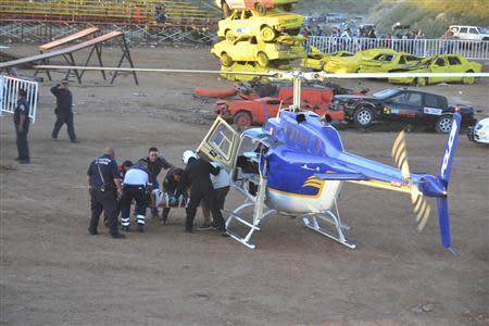 An injured spectator is wheeled by paramedics to a helicopter after a monster truck rammed a stand during a monster truck rally show at El Rejon park, on the outskirts of Chihuahua October 5, 2013. REUTERS/Eduardo Alanis/El Diario de Chihuahua