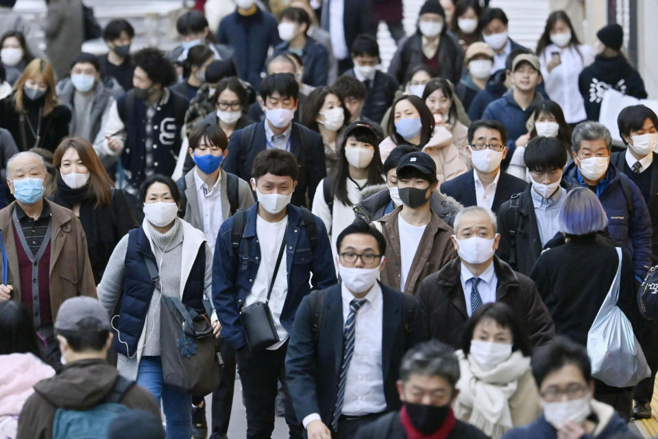 People wear face masks as they make their way through a street in Tokyo Friday, Nov. 27, 2020. Tokyo reported 570 new COVID-19 cases on Friday, a new record for Japan’s capital city as the country faces a surge in infections. (Yohei Nishimura/Kyodo News via AP)