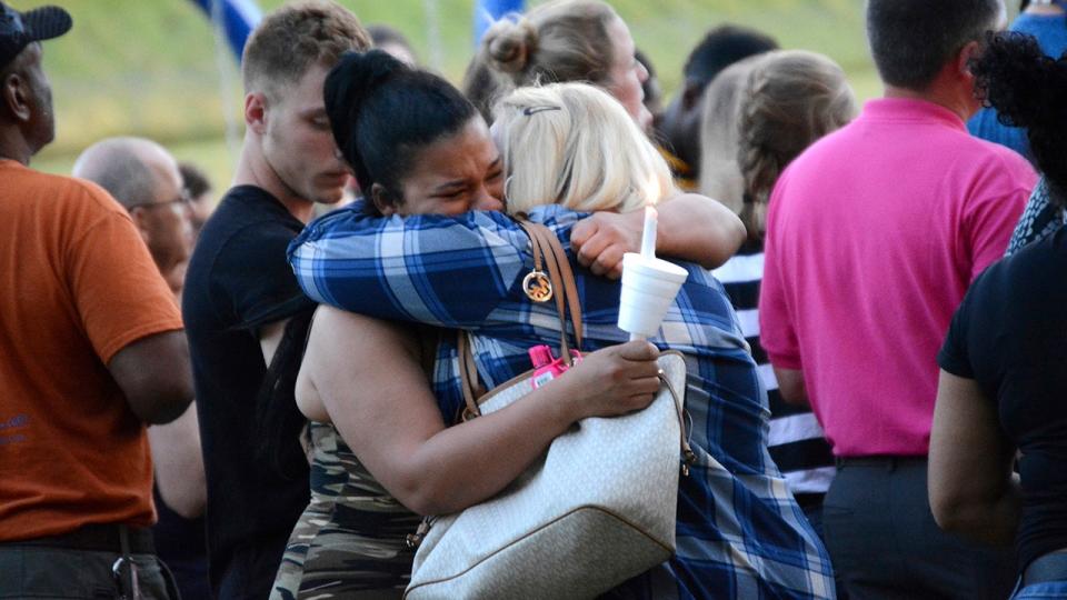 Mourners hugging each other.