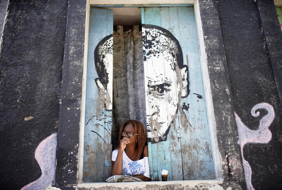 A woman looks from a window amid the new coronavirus pandemic at Morro da Providencia favela, Rio de Janeiro, Brazil, Thursday, Sept. 3, 2020. Rio de Janeiro is deploying a program to administer 20 thousand COVID-19 quick tests in the city's poor neighborhoods to track the progress of the disease. (AP Photo/Silvia Izquierdo)