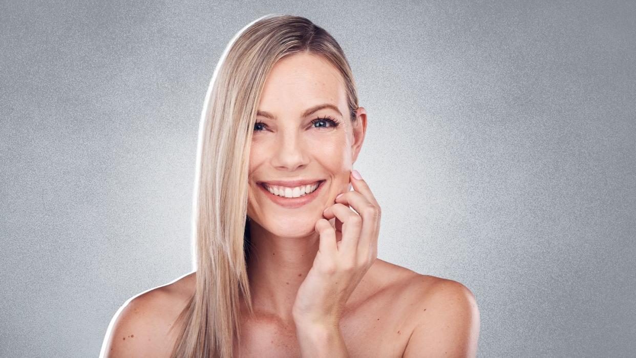 a woman smiling with her hand on her face