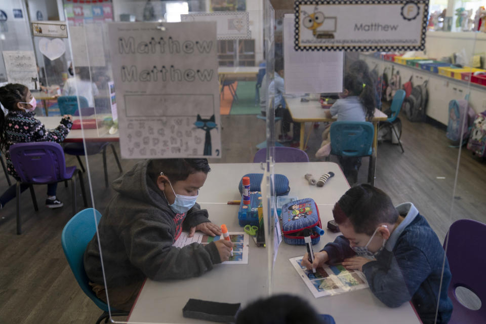 FILE - In this March 18, 2021, file photo, pre-kindergarten students work on their school work at West Orange Elementary School in Orange, Calif. The Centers for Disease Control and Prevention relaxed its social distancing guidelines for schools Friday, March 19, saying students can now sit 3 feet apart in classrooms. The new guidelines also remove recommendations for plastic shields or other barriers between desks. (AP Photo/Jae C. Hong)