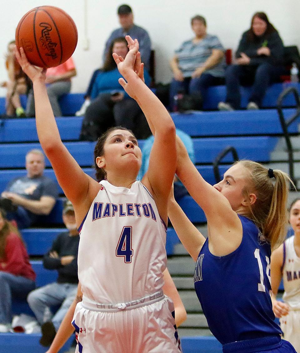 Mapleton High School's Bailey Davis (4) shoots as Northwestern High School's Mariah Thompson (14) defends during high school girls basketball action on Tuesday, Jan. 18, 2022 at Mapleton High School. TOM E. PUSKAR/TIMES-GAZETTE.COM