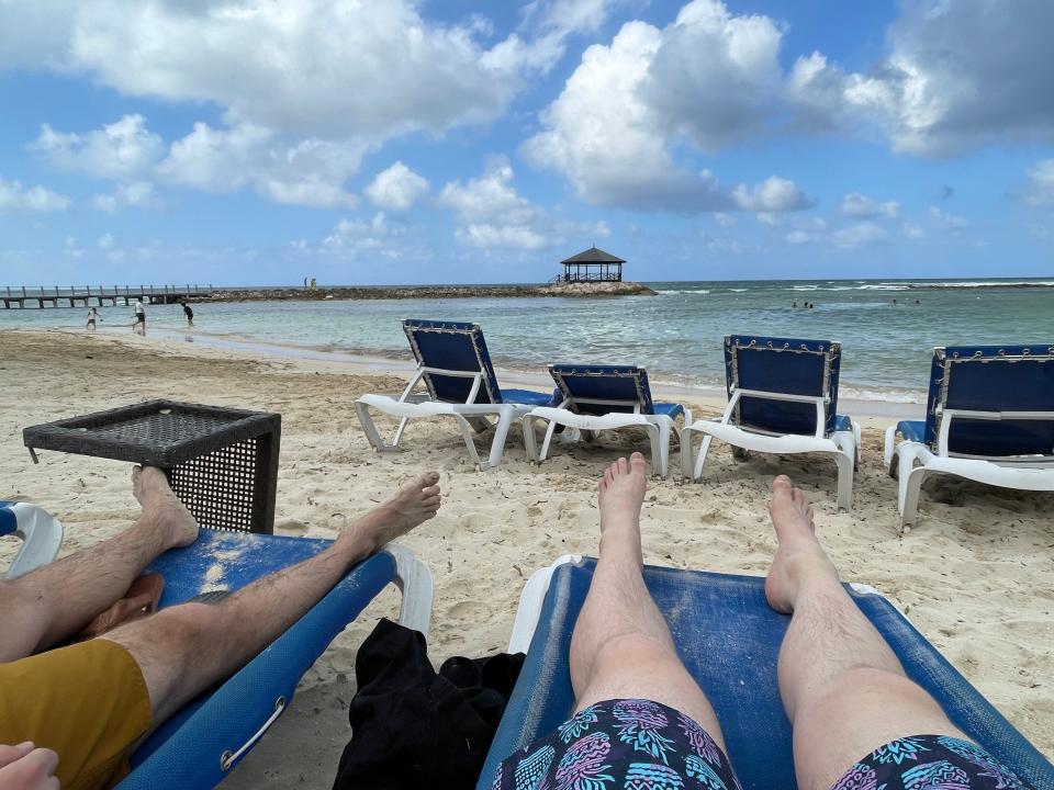 Jewel Grande in Montego Bay, writer and husband laying on beach relaxing with ocean in background