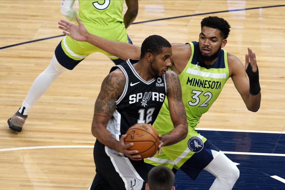 Minnesota Timberwolves' Karl-Anthony Towns, right, chases San Antonio Spurs' LaMarcus Aldridge who drives in the first half of an NBA basketball game Saturday, Jan. 9, 2021, in Minneapolis. (AP Photo/Jim Mone)