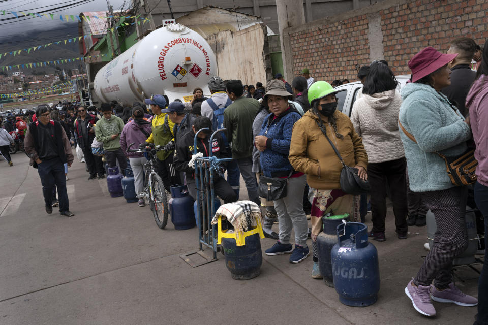 Residents line up to buy propane gas for cooking in downtown Cusco, Peru, Friday, Feb. 3, 2023. Gas delivery trucks have been affected by anti-government demonstrators blocking highways across the country, amid political turmoil over the removal of former President Pedro Castillo who was later arrested for trying to dissolve Congress. (AP Photo/Rodrigo Abd)