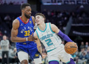 Charlotte Hornets guard LaMelo Ball (2) drives around Denver Nuggets forward Jeff Green (32) during the first half of an NBA basketball game on Monday, March 28, 2022, in Charlotte, N.C. (AP Photo/Rusty Jones)