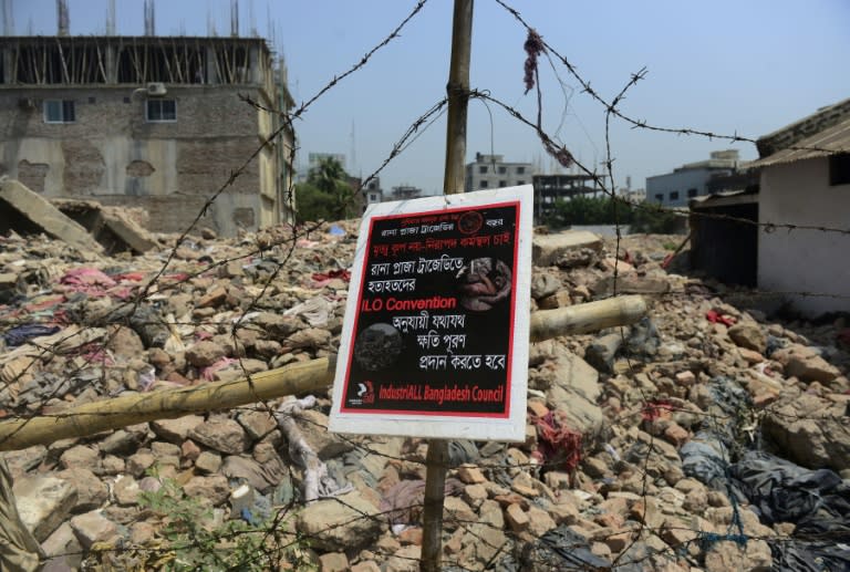 A poster at the scene of the Rana Plaza building collapse reads "We want a safe work place, not a death trap'