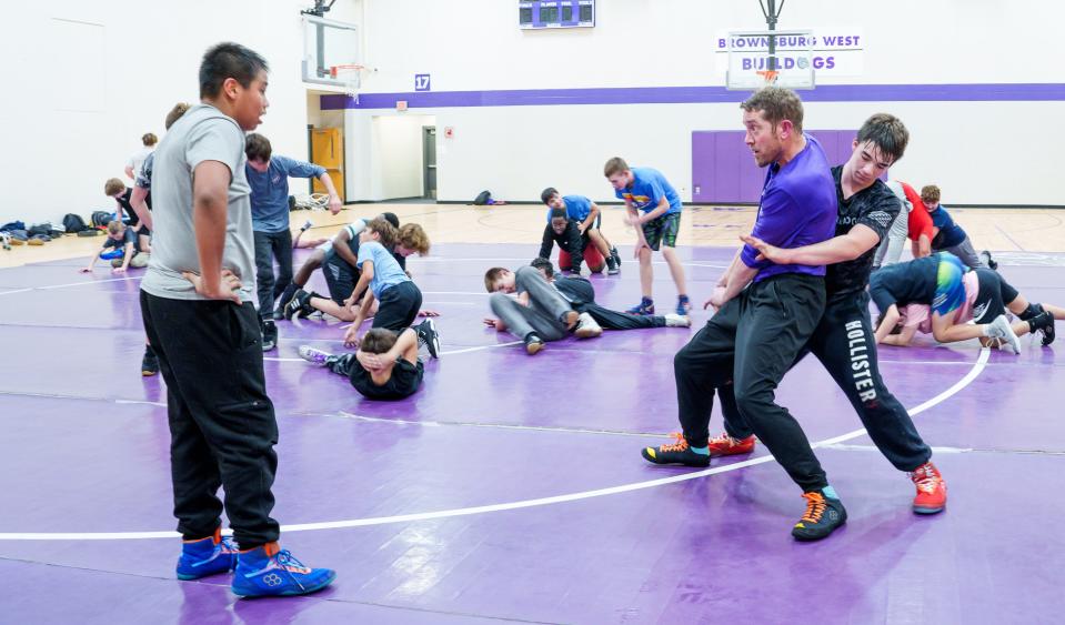Brownsburg West Middle School Bulldogs wrestling coach Patrick Frepan shows a wrestler how to reverse a hold Tuesday, Feb. 26, 2024, during practice ahead of the Bulldogs' conference meet Saturday.