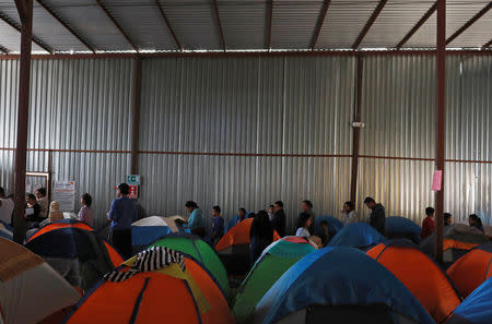 Migrants queue for food inside a shelter in Tijuana, Mexico April 6, 2019. Picture taken April 6, 2019. REUTERS/Carlos Jasso/Files