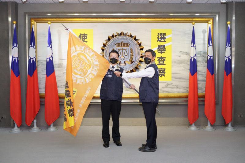 調查局長王俊力（左）將印有「選舉查察、使命必達」大型旗幟逐一授與負責第一線執行外勤調查處站主管，展現查賄決心。（調查局提供）