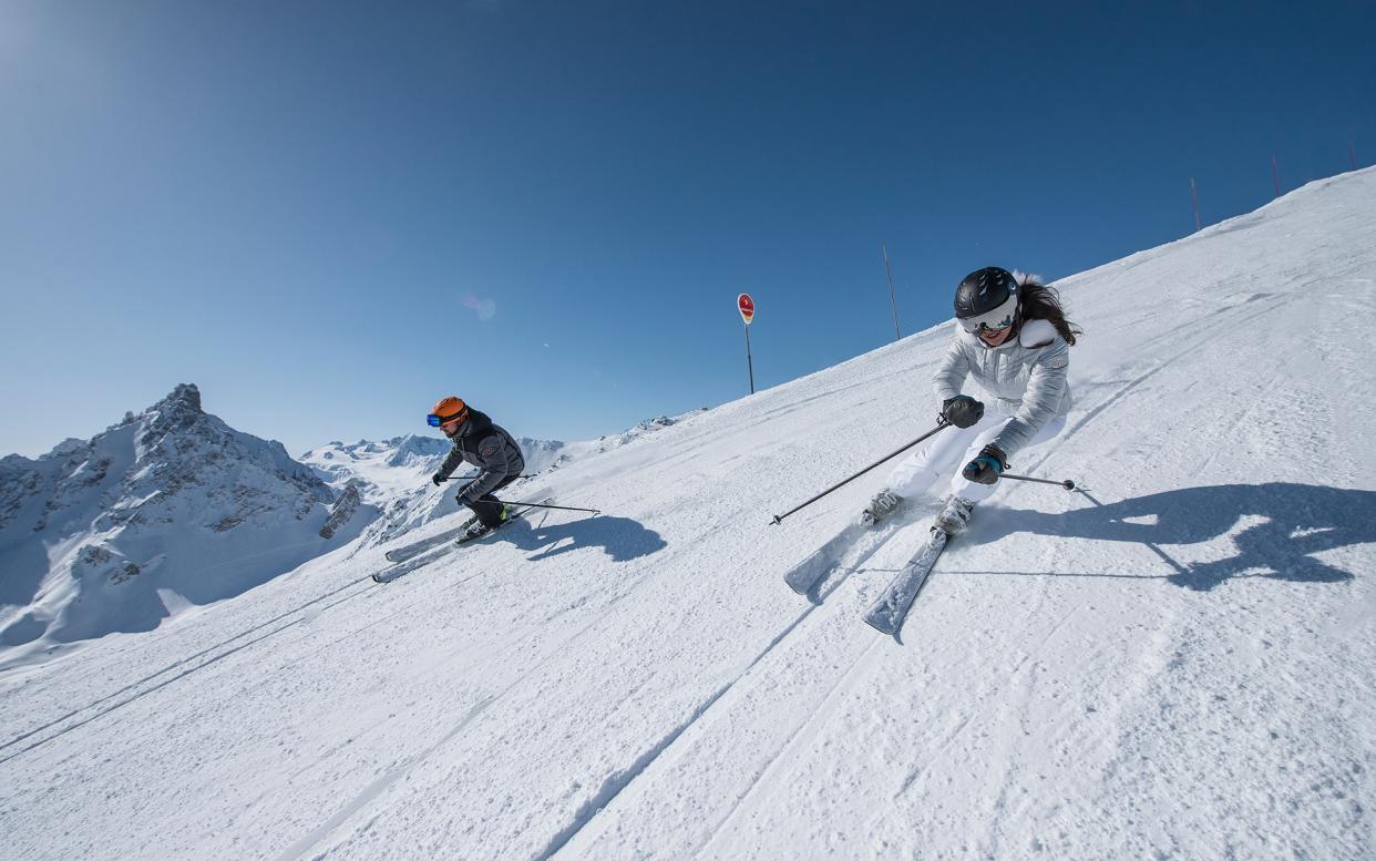 skiers on slope in courchevel - david andre/courchevel tourisme