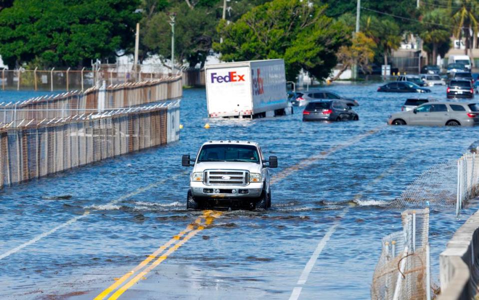 El conductor de un camión maneja por una calle inundada por las fuertes lluvias en West Perimeter Road en Fort Lauderdale, Broward, Florida, el jueves 13 de abril de 2023.