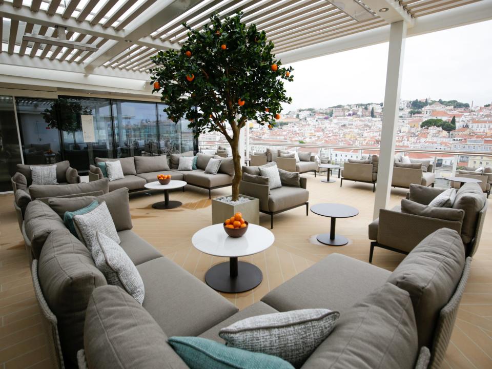 empty alfresco seating near fake orange tree on Silversea Silver Ray