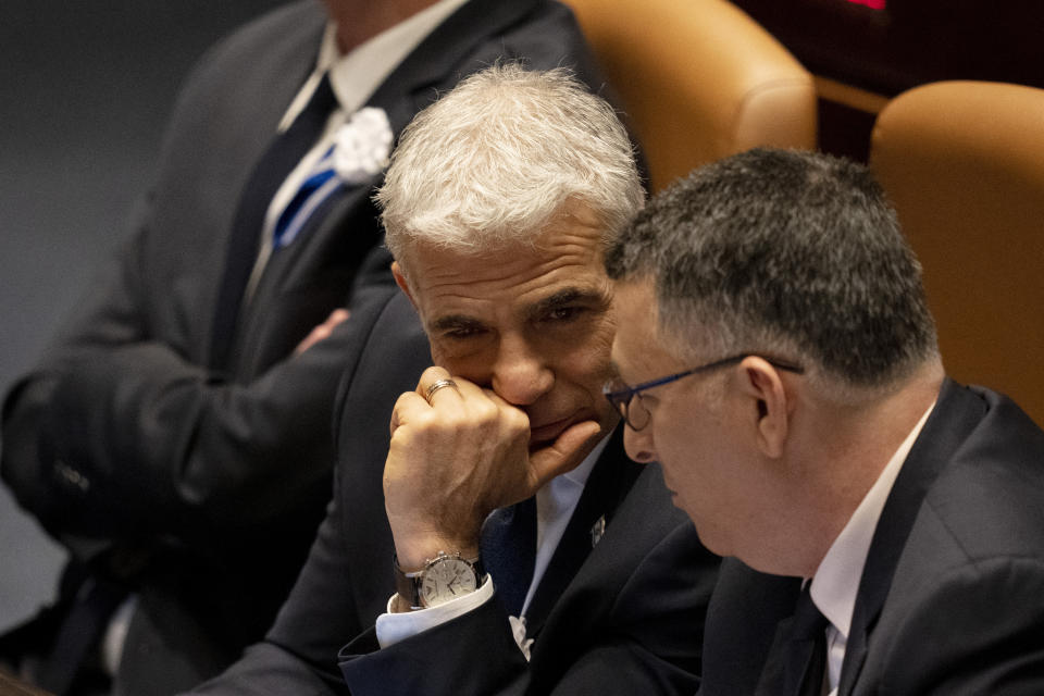 CORRECTS TO SWEARING-IN OF PARLIAMENT, NOT GOVERNMENT - Israel's outgoing Prime Minister Yair Lapid, center, speaks with Gideon Saar at the swearing-in ceremony for Israel's parliament, at the Knesset, in Jerusalem, Tuesday, Nov. 15, 2022. (AP Photo/ Maya Alleruzzo, Pool)