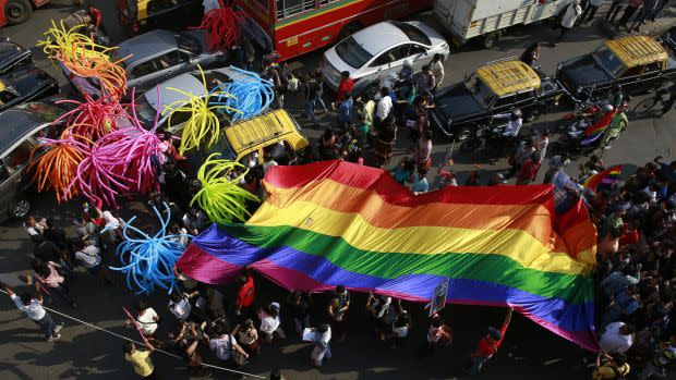 Participants holding a rainbow flag pass through a junction during a gay pride parade, which is promoting gay, lesbian, bisexual and transgender rights, in Mumbai