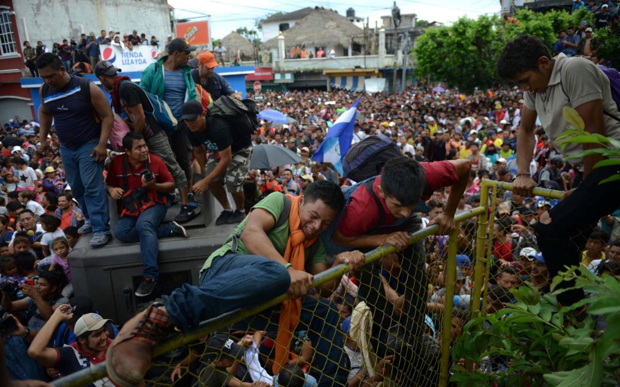 Thousands of migrants rush across the border towards Mexico, in Tecun Uman, Guatemala - AP