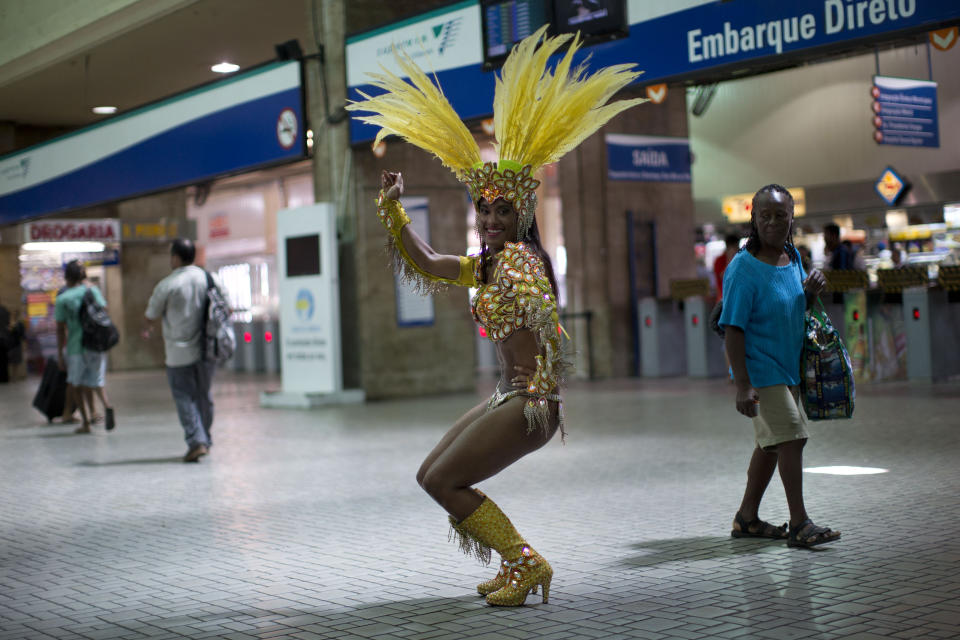 In this photo taken Saturday, Feb. 2, 2013, samba dancer Diana Prado performs during a carnival parade at central station in Rio de Janeiro, Brazil. Prado spends her daylight hours working as a supervisor at a call center. At night, she is a samba dancer, or "passista," as they're known in Portuguese. Prado made her Carnival debut at age 19, after auditioning for a spot with the Sao Clemente, one of 13 top-tier schools that will compete for the annual titles at the Sambadrome this weekend. (AP Photo/Felipe Dana)