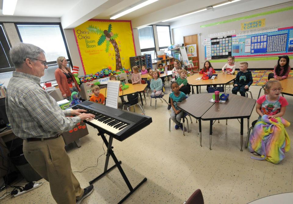 Volunteer Ken Abbott, a retired Weymouth schoolteacher, conducts a singalong on his keyboard with Nash School kindergarten students. His daughter, Melissa Staffier, standing second from left, is the kindergarten teacher and his daughter.