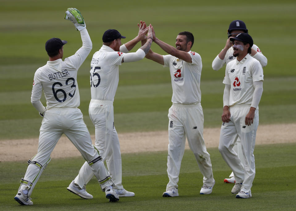 England's Mark Wood, third right, celebrates with teammates the dismissal of West Indies' Shai Hope during the fifth day of the first cricket Test match between England and West Indies, at the Ageas Bowl in Southampton, England, Sunday, July 12, 2020. (Adrian Dennis/Pool via AP)