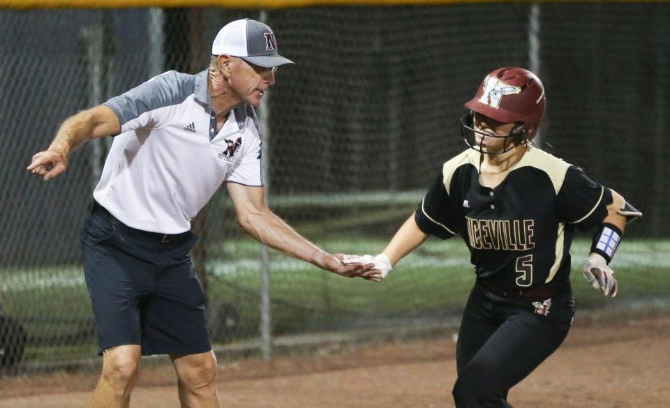 Niceville coach Danny Hensley congratulates Mary Owens after she belted a home run during the Niceville Tate District championship softball game at Niceville. The Eagles won the game and title 8-1.