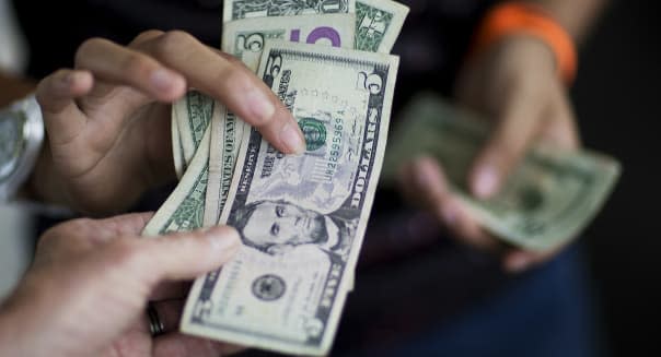 FILE - In this June 6, 2015, file photo, a customer, bottom, pays for goods while shopping at the Atlanta Farmers Market in Atlanta. The Commerce Department issues the first of three estimates of how the U.S. economy performed in the July-September quarter on Thursday, Oct. 29, 2015. (AP Photo/David Goldman, File)